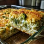 Close-up of a thick slice of creamy broccoli casserole topped with a golden, crunchy breadcrumb crust.