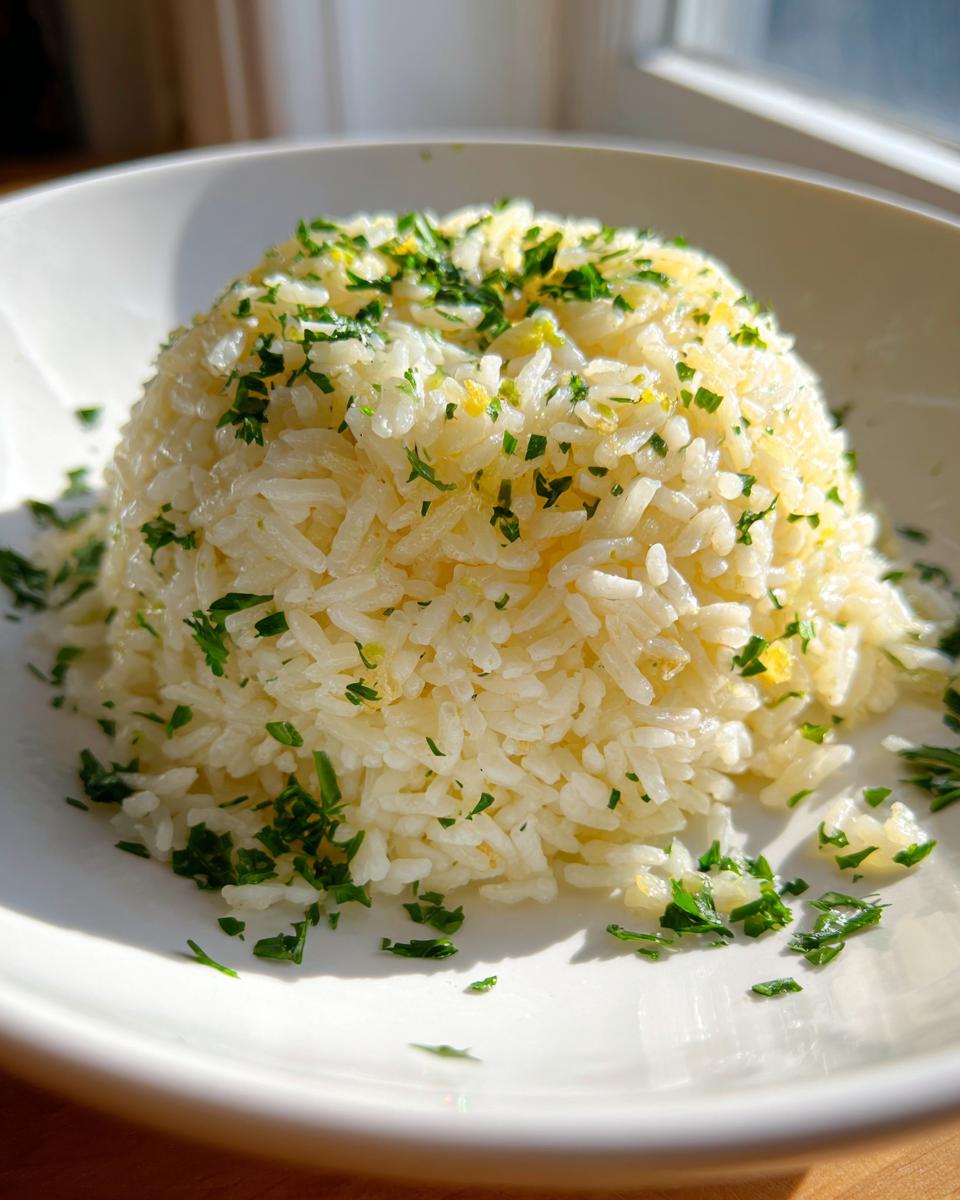 A molded serving of fluffy garlic butter rice topped generously with fresh chopped parsley.