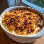 Close-up of hot Jalapeño popper dip in a white baking dish, topped with golden breadcrumbs and crispy bacon.