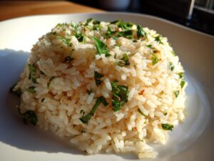 A perfectly molded serving of fluffy garlic butter rice topped generously with fresh chopped green herbs.