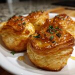 Four golden, flaky puff pastry goat cheese and honey bites drizzled with honey and topped with fresh thyme.