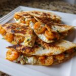Close-up of four wedges of perfectly cooked shrimp quesadilla filled with seasoned shrimp and melted cheese.