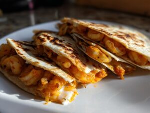 Close-up of three folded and grilled shrimp quesadilla wedges filled with seasoned shrimp and melted cheese.