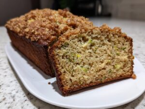 Close-up of moist zucchini banana bread, showing the crumb topping and shredded zucchini texture inside.