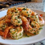 Close-up of perfectly cooked air fryer frozen shrimp tossed in garlic butter and fresh parsley.
