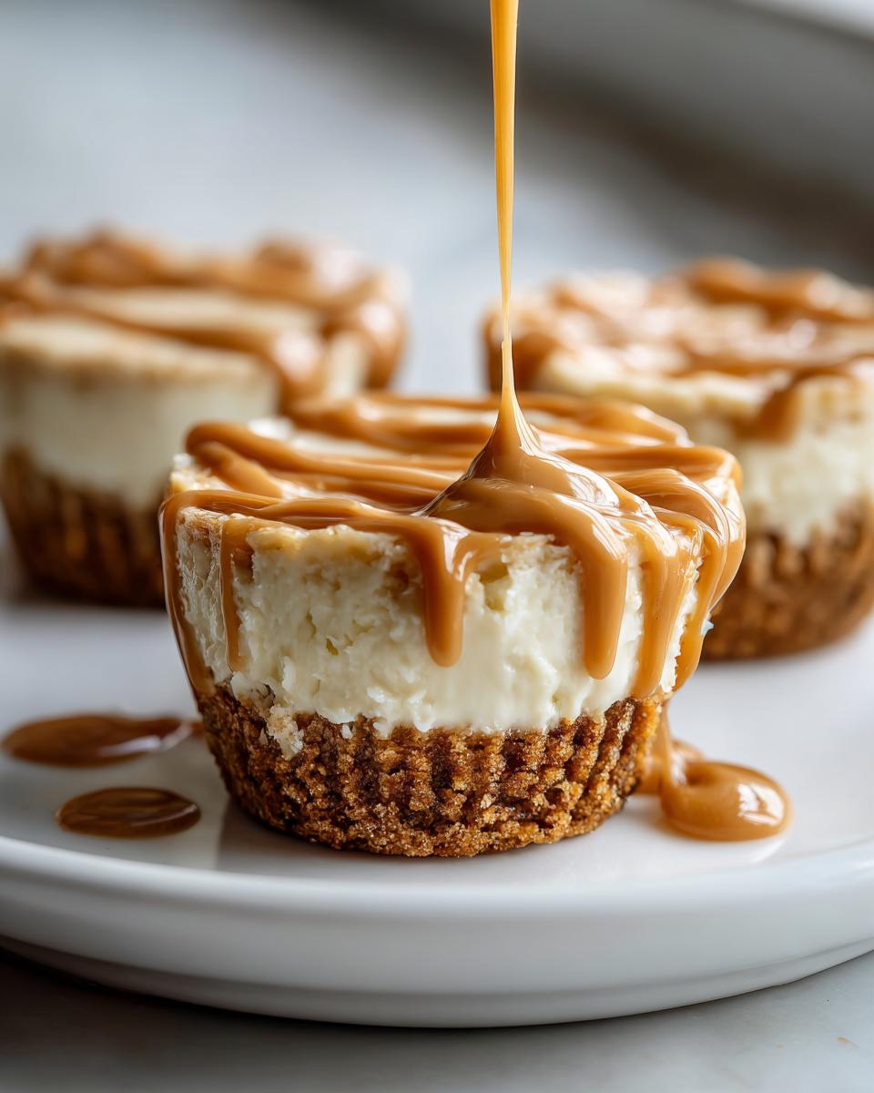 A close-up of a cookie butter cheesecake cup being drizzled with thick caramel sauce.