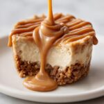 Close-up of a cookie butter cheesecake cup being drizzled heavily with thick caramel sauce.