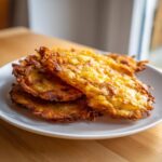 A stack of golden-brown, crispy fried potato pancakes ready to be used as potato tacos.