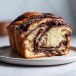 Close-up of a freshly baked chocolate babka loaf showing the beautiful swirl of chocolate filling inside the soft bread.
