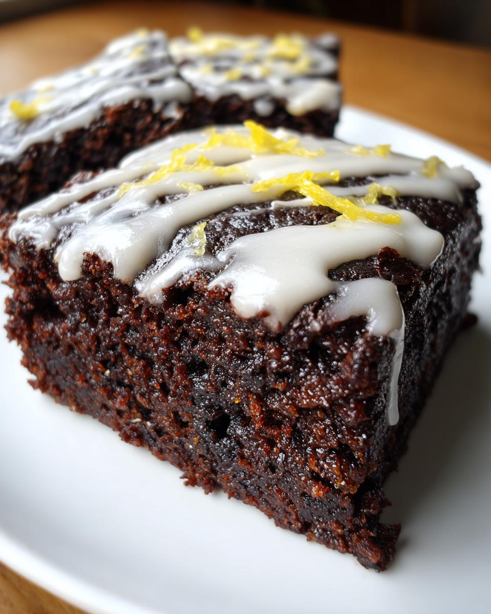 Close-up of two fudgy Lemon Brownies topped with white glaze and bright yellow lemon zest.