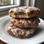 A stack of three delicious coffee cake cookies topped with cinnamon streusel and white glaze.