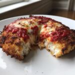 Close-up of a perfectly cooked chicken parmesan recipe showing melted cheese pull and crispy breading.