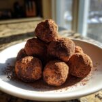 A pile of rich, dark chocolate truffles dusted heavily with cocoa powder, representing the easy cool whip candy recipe.